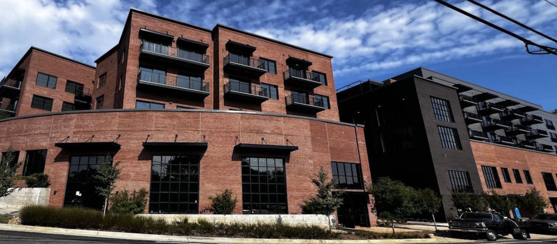 Completed multistory brick residential building with storefront base