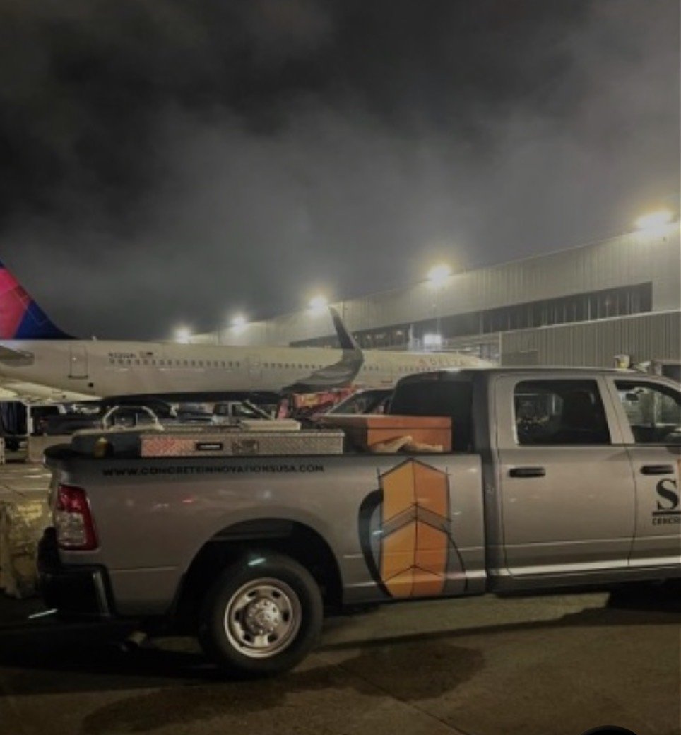 Concrete Construction Innovations truck on the ramp beside a Delta aircraft at Hartsfield-Jackson Atlanta International Airport